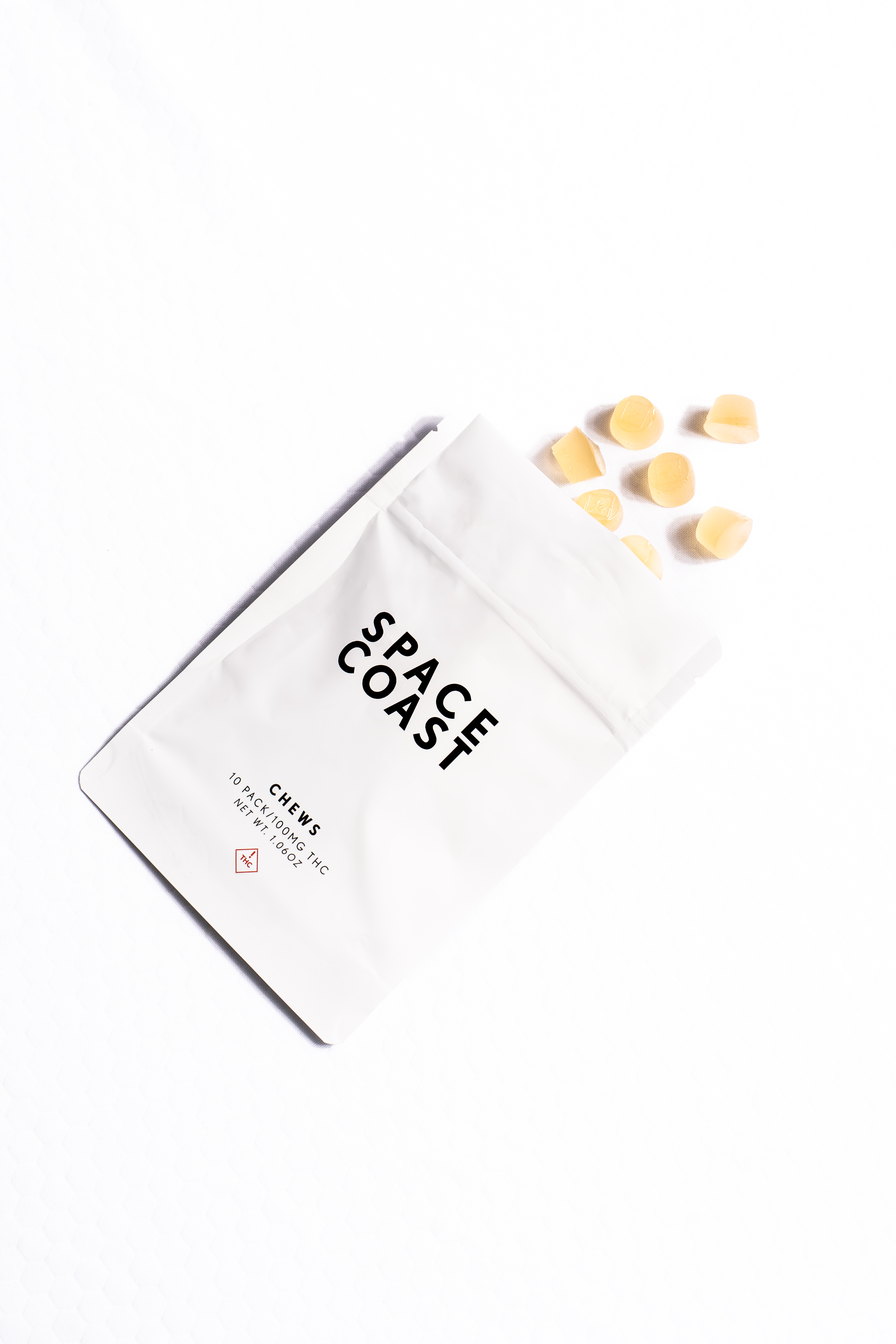 Space Coast Chews 10-pack pouch with yellow chews spilling onto a white background
